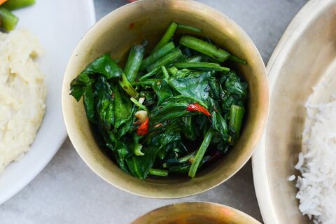 Deatils of one of the bronze bowls with Saag (Nepali spinach)